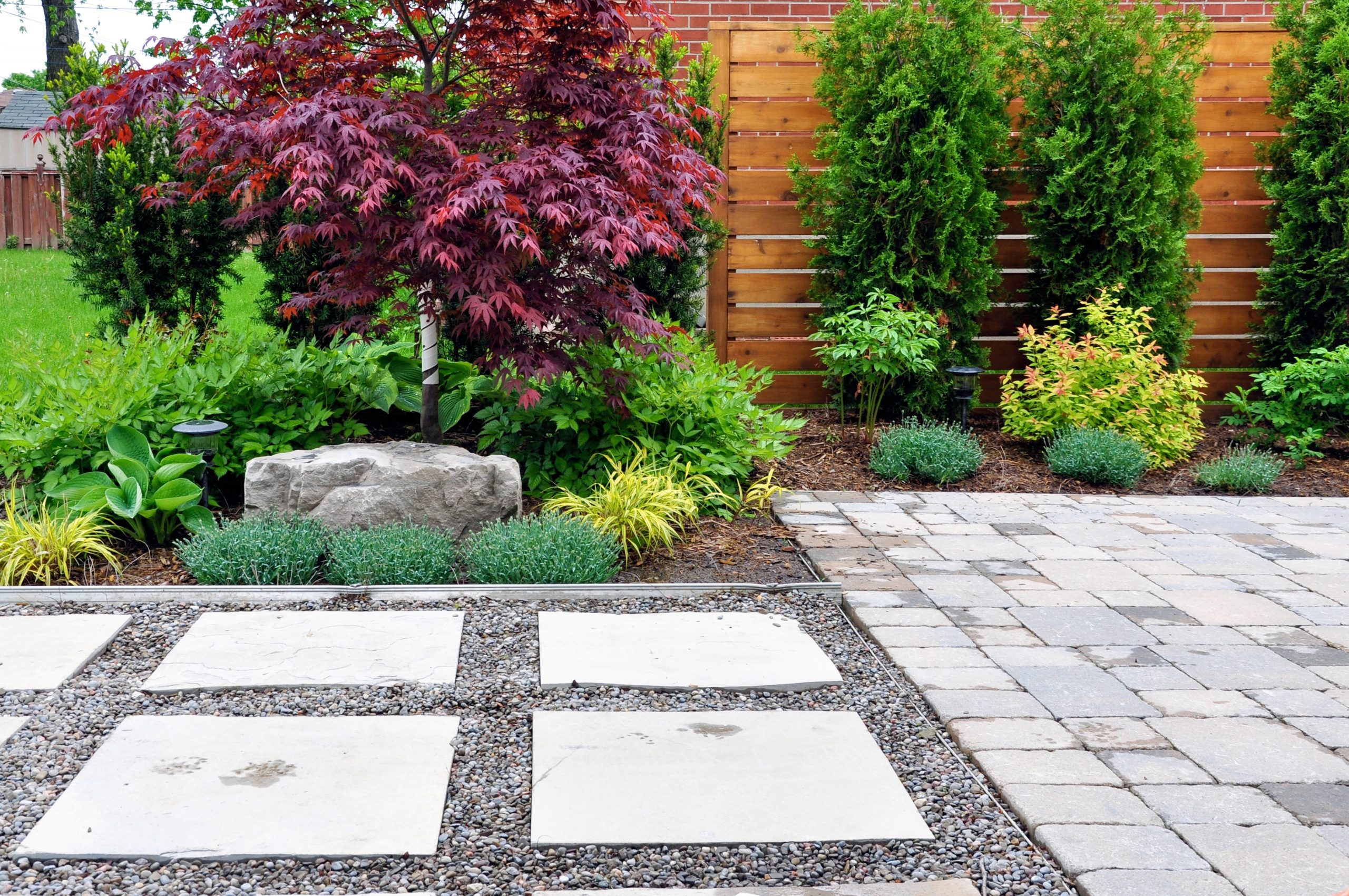 A beautifully installed flagstone patio with natural stone and landscaping.